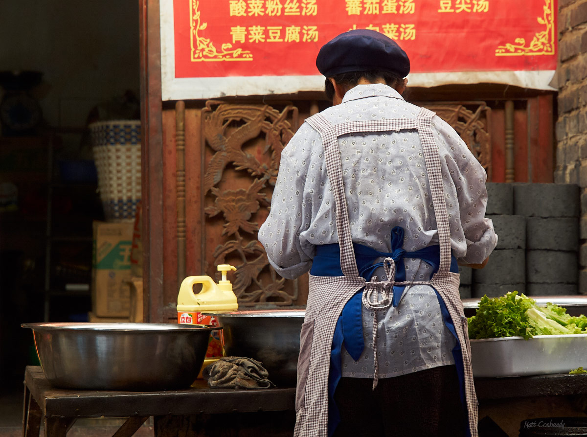 Chinese food chef preparing vegetables in Yunnan public market