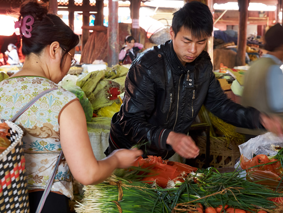 woman buying vegetables at the Ancient City Zhongyi Market in Lijiang